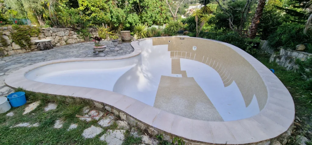 Pose des plaques de mosaïque sous la margelle de la piscine